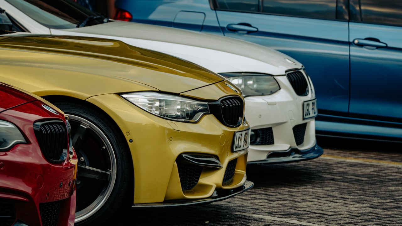 Close-up shot of luxury cars parked side by side in eMalahleni, showcasing vibrant car colors.